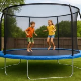 Trambolina sa zaštitnom mrežom u dvorištu i deca koja skaču.